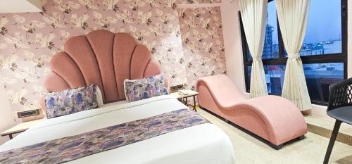 a hotel room with a bed and two chairs at Hotel Nova Bling in Rajkot
