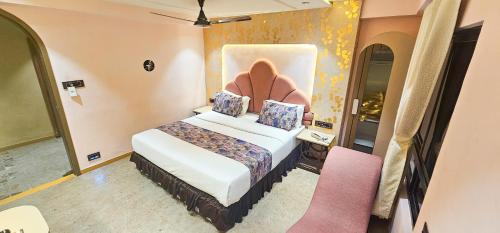 a hotel room with a bed with a headboard at Hotel Nova Bling in Rajkot