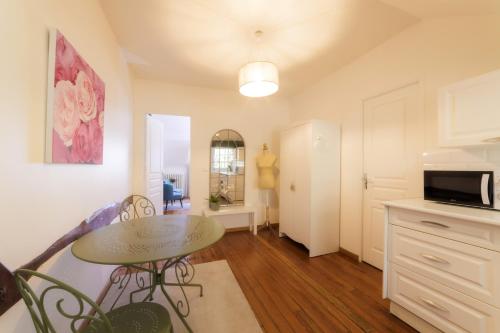 un salon avec une table et une cuisine dans l'établissement Domaine de l'Orangerie - La Roseraie, à Boissise-la-Bertrand