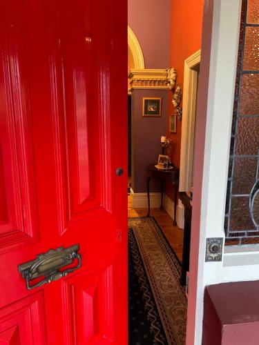 a red door leading to a hallway with at The Red Door: Expansive Home/Pool/4 BR w Ensuites in Glenelg