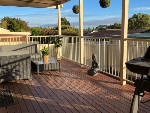 a cat sitting on a wooden deck at Yass Valley Stays - Convenient & Comfortable in Yass