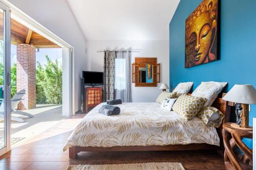 Schlafzimmer mit blauen Wänden und einem Bett mit Kissen in der Unterkunft La villa du Moulin Castin in Castin