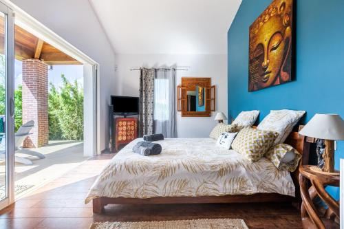 a bedroom with blue walls and a bed with pillows at La villa du Moulin Castin in Castin