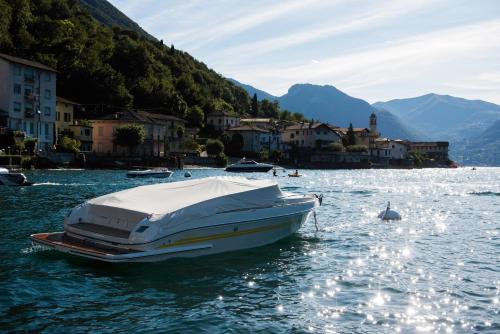 um barco branco na água perto de uma cidade em Casa Carlotta Lake Como em Lezzeno