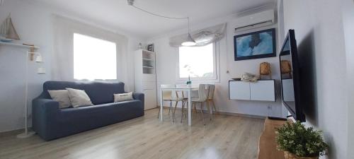 uma sala de estar com um sofá azul e uma mesa em Apartamento en casa de campo cerca de la playa em Pals