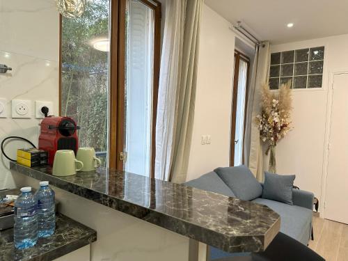 eine Küche mit Granitarbeitsplatte und ein Wohnzimmer in der Unterkunft Charme Appartement à Paris13 in Paris