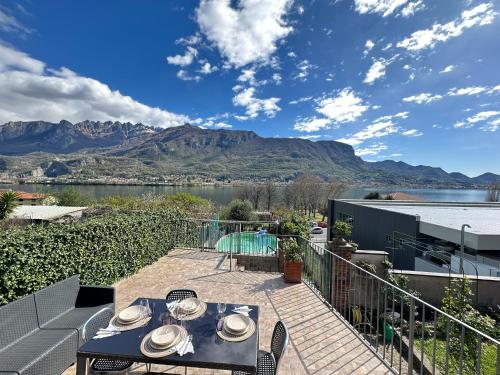 a patio with a table and a view of a mountain at Le Rose Sul Lago in Pescate