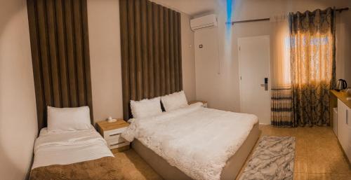 a small bedroom with two beds and a window at Aromë natyre by AlaraFarm in Durrës