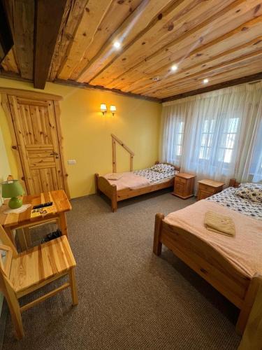 a bedroom with two beds and a wooden ceiling at Atpūtas komplekss Sonāte in Vecstāmeriena