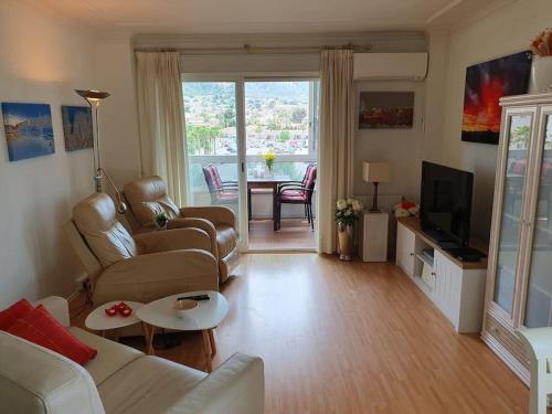 a living room with a couch and a tv at Lys og trivelig leilighet sentralt i Albir in Albir