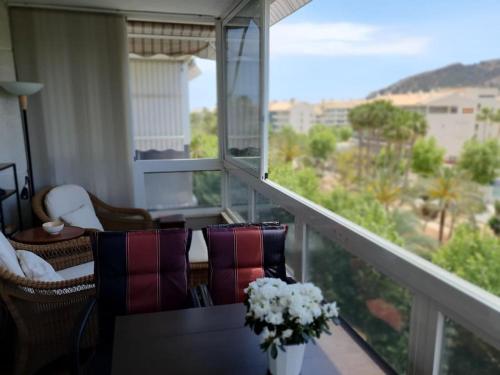 a balcony with chairs and a table with flowers on it at Lys og trivelig leilighet sentralt i Albir in Albir