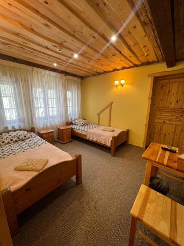 a bedroom with two beds and a wooden ceiling at Atpūtas komplekss Sonāte in Vecstāmeriena