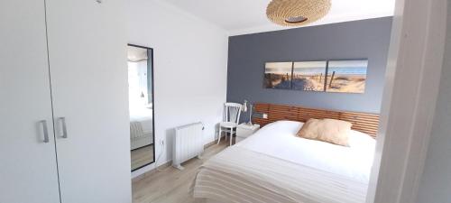 a bedroom with a white bed and a blue wall at Apartamento en casa de campo cerca de la playa in Pals