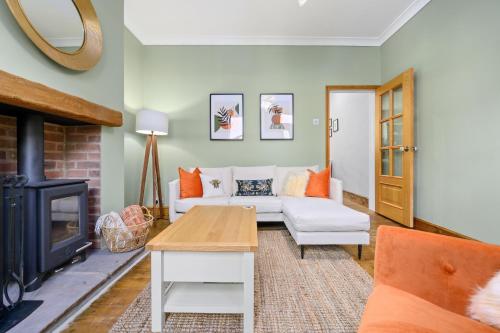een woonkamer met een bank en een open haard bij 2-Bedroom Luxury Cottage - Long Stays in Cheadle
