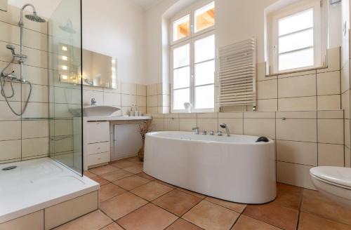 uma casa de banho com uma banheira, um lavatório e um WC. em Salon em Heringsdorf