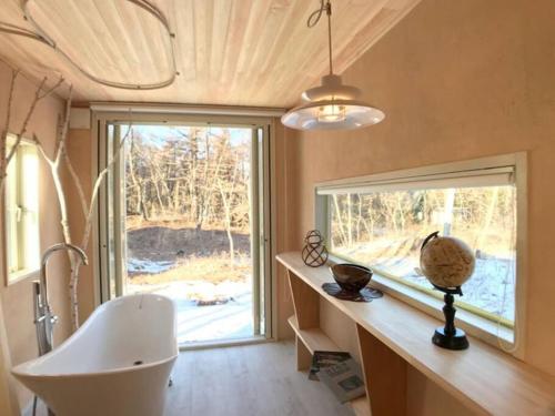 baño con bañera, lavabo y ventana en Kitakaruizawa Morino Bessou NO9, en Tsumagoi