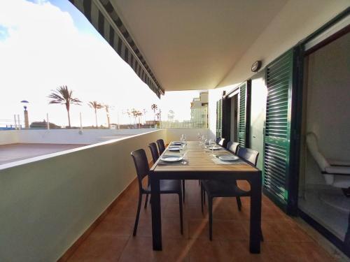 a dining room with a table and chairs on the roof at Beachfront flat with pool in Quarteira