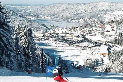 a person is skiing down a snow covered slope at Charmant logis Gérardmer in Gérardmer