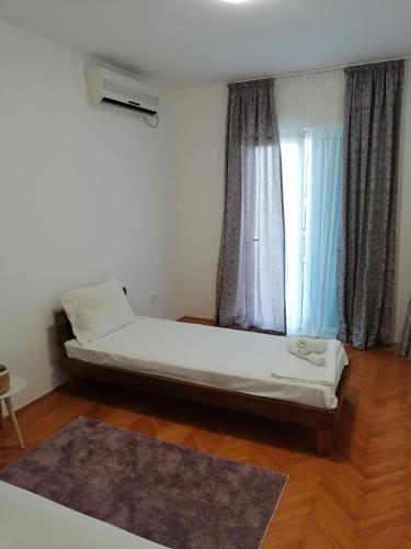 a bed sitting in a room with a window at House Leana Herceg Novi in Herceg-Novi