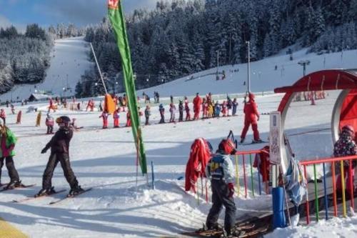 a group of people skiing on a ski slope at Charmant logis Gérardmer in Gérardmer