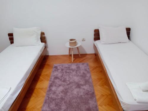 two beds in a room with a rug at House Leana Herceg Novi in Herceg-Novi