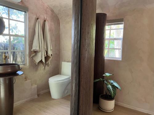 a bathroom with a toilet and a window at Terra Villeta - at lumicollection in Miami