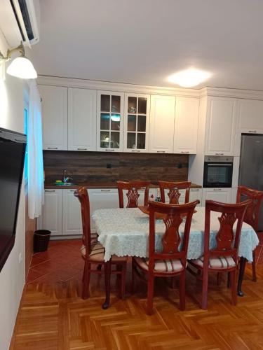 a kitchen with a table and chairs and white cabinets at House Leana Herceg Novi in Herceg-Novi