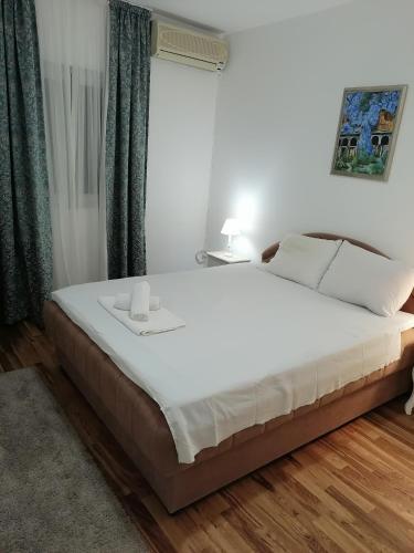 a bedroom with a large white bed with two candles on it at House Leana Herceg Novi in Herceg-Novi