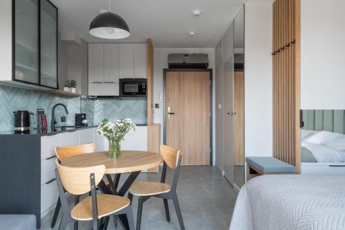 a kitchen and a dining room with a table and chairs at AVAPARTS Apartament AQUA in Jastarnia