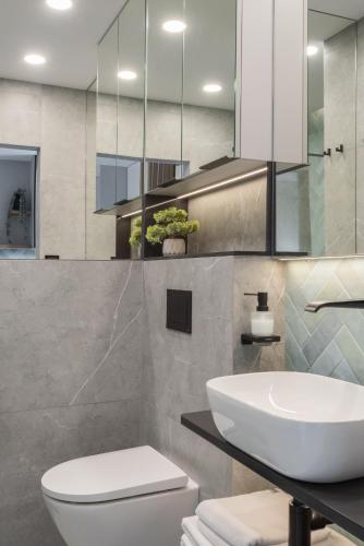 a bathroom with a white toilet and a sink at AVAPARTS Apartament AQUA in Jastarnia