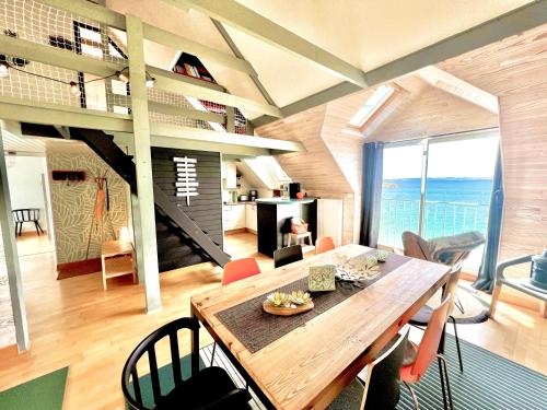 a living room with a wooden table and chairs at Glaz Ocean in Douarnenez