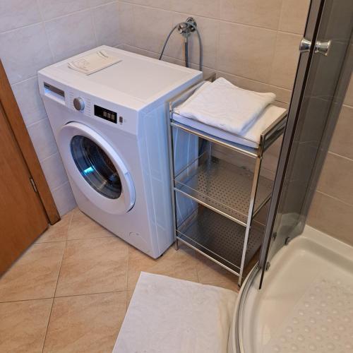 a washing machine in a bathroom next to a shower at Apartman Petra in Zadar