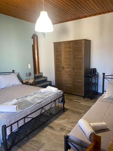 a bedroom with two beds and a wooden cabinet at Studios Maro in Skala Kallonis