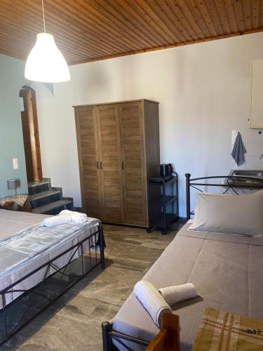 a bedroom with two beds and a wooden cabinet at Studios Maro in Skala Kallonis