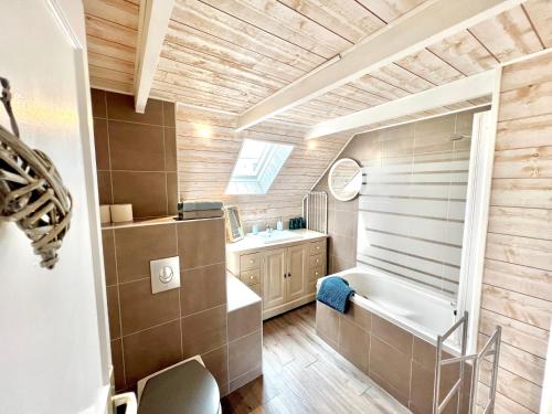 a bathroom with a tub and a sink at Glaz Ocean in Douarnenez