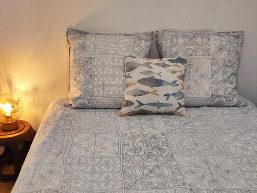 ein Bett mit Kissen drauf mit in der Unterkunft La petite Maison de La Saline-les-Bains in Saint-Paul