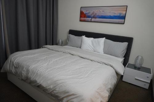 a bedroom with a bed with a white comforter at Peace House-private room with bathroom for 2 guest in Dubai