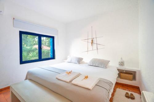 - une chambre avec un grand lit blanc et des serviettes dans l'établissement Family Paradise: Exquisite Retreat for Holidays, à São Miguel de Rio Torto