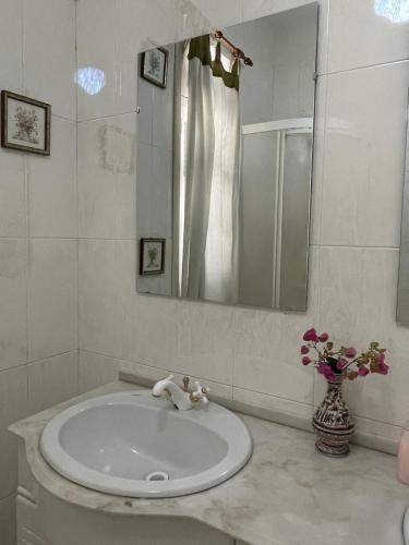 a white bathroom with a sink and a mirror at Vila São Gonçalo in Funchal