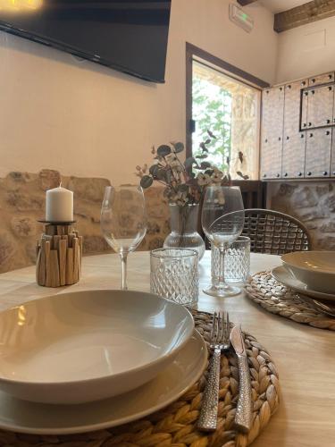 a table with a plate and wine glasses on it at El Capricho de la Serranía I in Tragacete