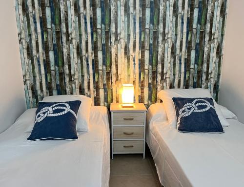 two beds sitting next to each other in a bedroom at BLAU Apartamento frente a los canales y las puestas de sol de Roses in Roses