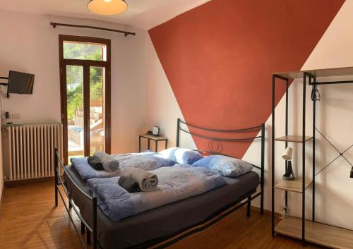 a bedroom with two beds and a red wall at Villa Angelina in Cannero Riviera