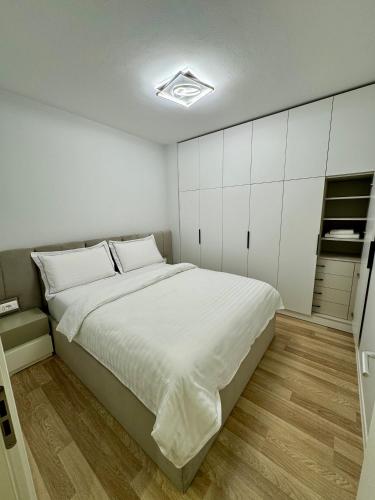 a bedroom with a large bed with white cabinets at Center of Tirana - Apartment in Tirana