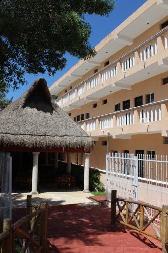 un edificio con un tetto di paglia di fronte di Hotel Turquesa Maya a Felipe Carrillo Puerto