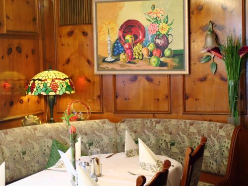 a dining room with a table and a painting on the wall at Hotel Garni in der Breite in Albstadt
