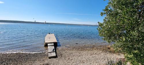 a wooden post on the shore of a body of water at Beachfront House Nella with full privacy in Jasenice