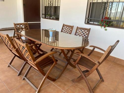 a dining room table with chairs and a glass top at Casa Rural La Encina in Azuel