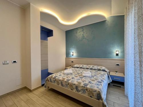 a bedroom with a bed and a blue wall at B&B Galatea in Santa Domenica