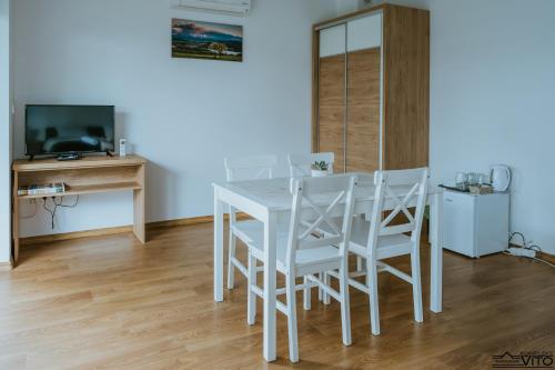 a white dining room table and chairs in a room at Kompleks Tawerna Vito - Apartamenty Vito in Czorsztyn