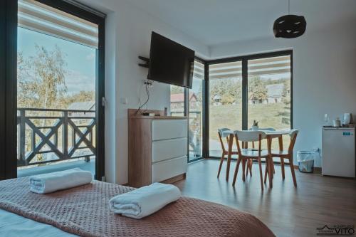 1 dormitorio con 1 cama y comedor con mesa en Kompleks Tawerna Vito - Apartamenty Vito en Czorsztyn